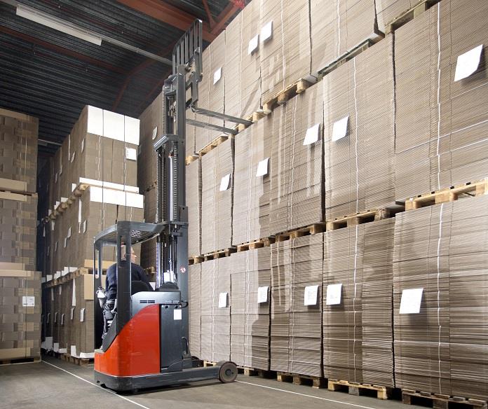 A forklift is parked in front of stacks of boxes.