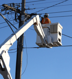 A man is using a BUCKET TRUCK AERIAL LIFT TRAINING & CERTIFICATION to work on a power pole.