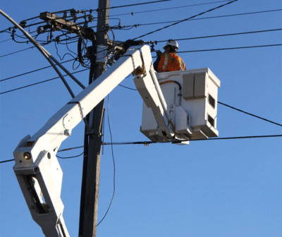 A man is using a BUCKET TRUCK AERIAL LIFT TRAINING & CERTIFICATION to work on a power pole.