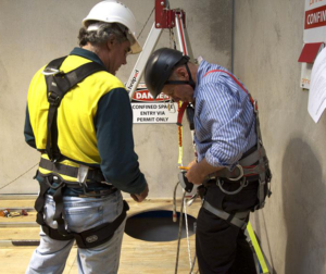Two men in safety harnesses and a helmet.