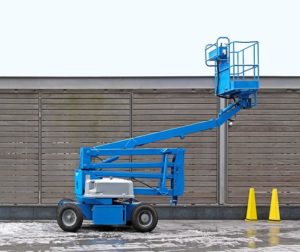 A blue lift parked next to a building.
