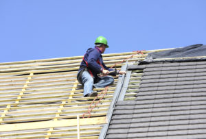 A man on top of a roof working.