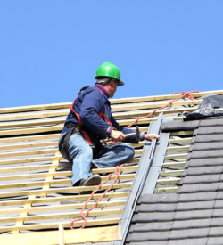 A man undergoing WORKING AT HEIGHTS TRAINING & REFRESHER COURSES while working on a roof.