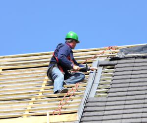 A man undergoing WORKING AT HEIGHTS TRAINING & REFRESHER COURSES while working on a roof.