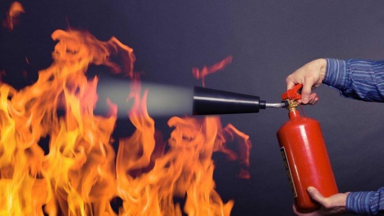 A person is using a fire extinguisher to put out the flames.